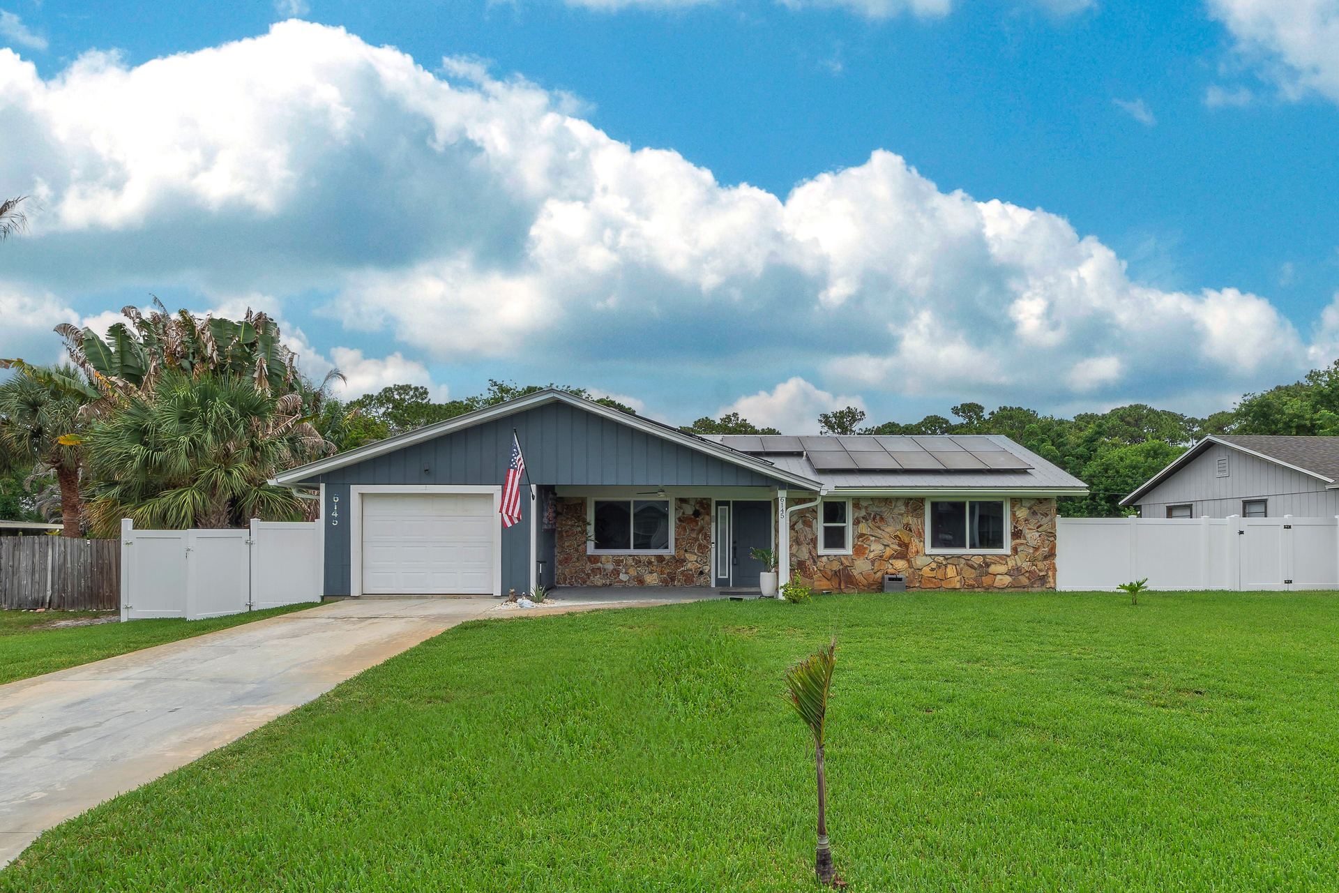 Daytime front exterior view of the single-story home with stone accents and attached garage
