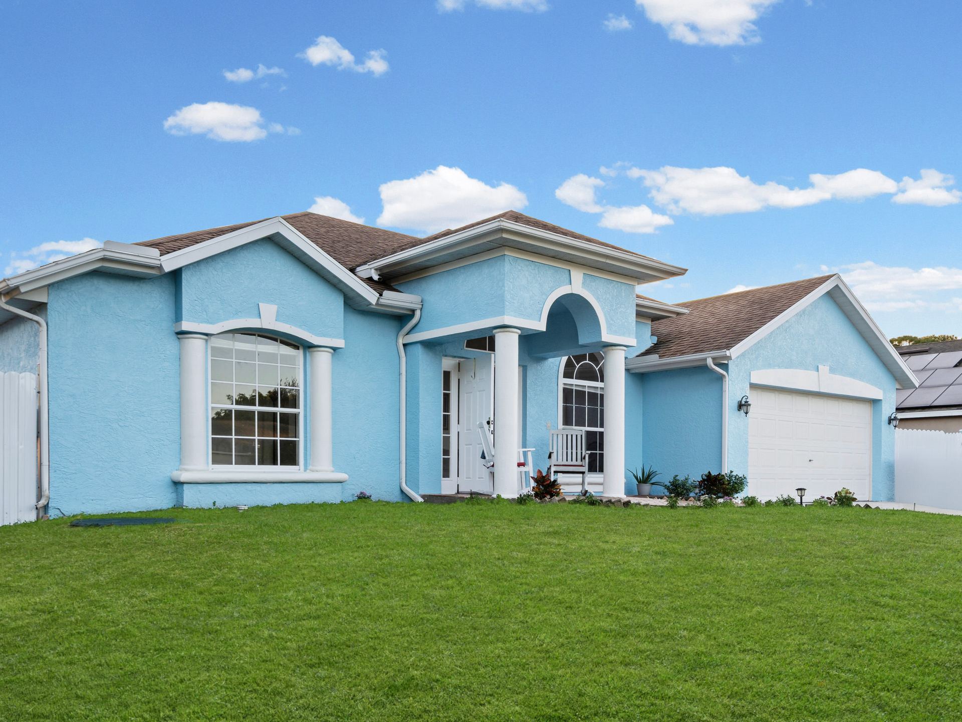 Front exterior daytime view of the powder-blue single-story home